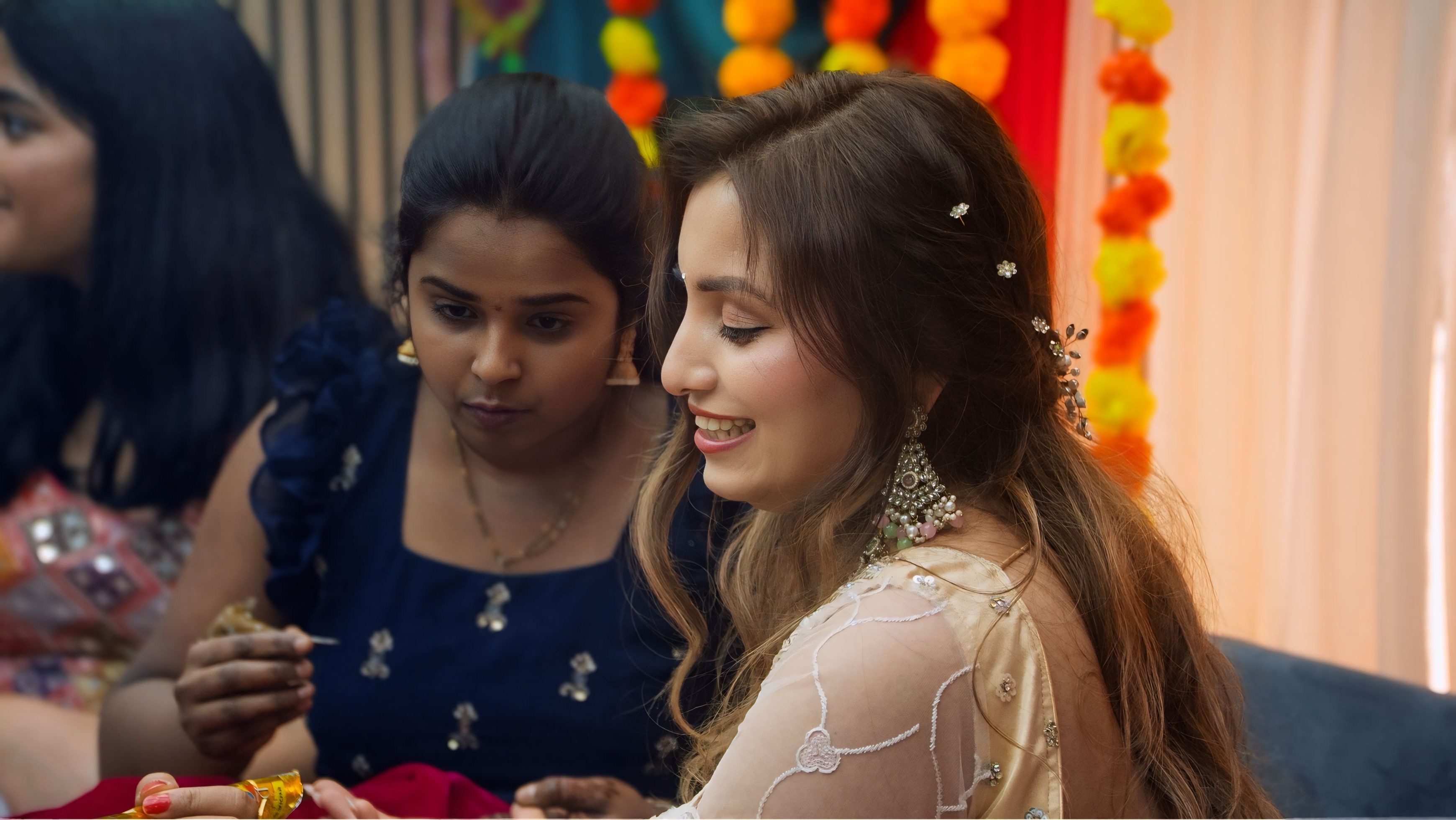 Joyful mehndi moment — bride laughing as henna is applied